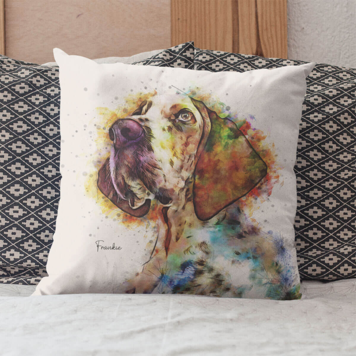 Decorative pillow with a colorful dog illustration on a bed with patterned pillows.